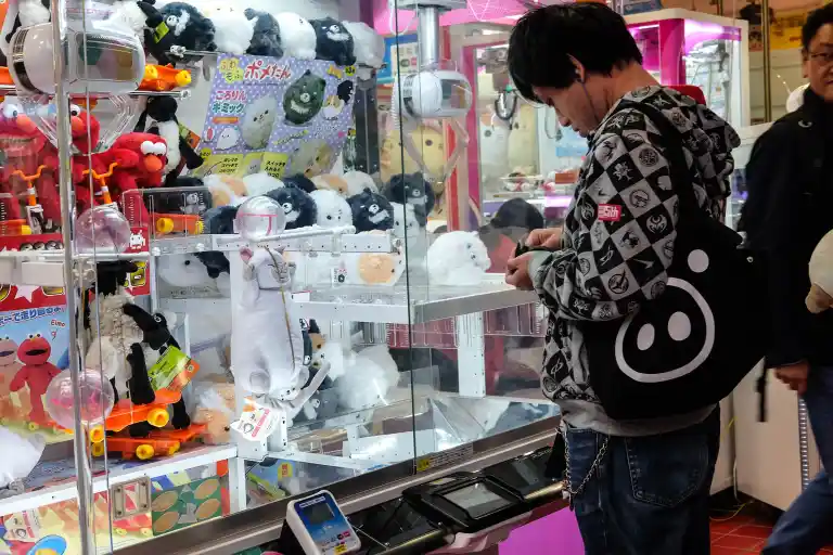 Japanese man playing UFO catcher in Tokyo