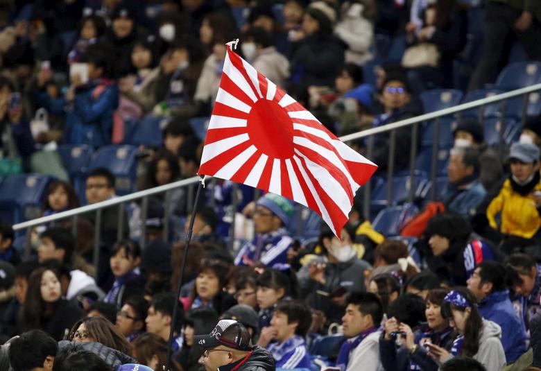 Japanese supporters football game holding a rising sun flag